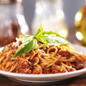 spaghetti dinner with meat sauce and basil